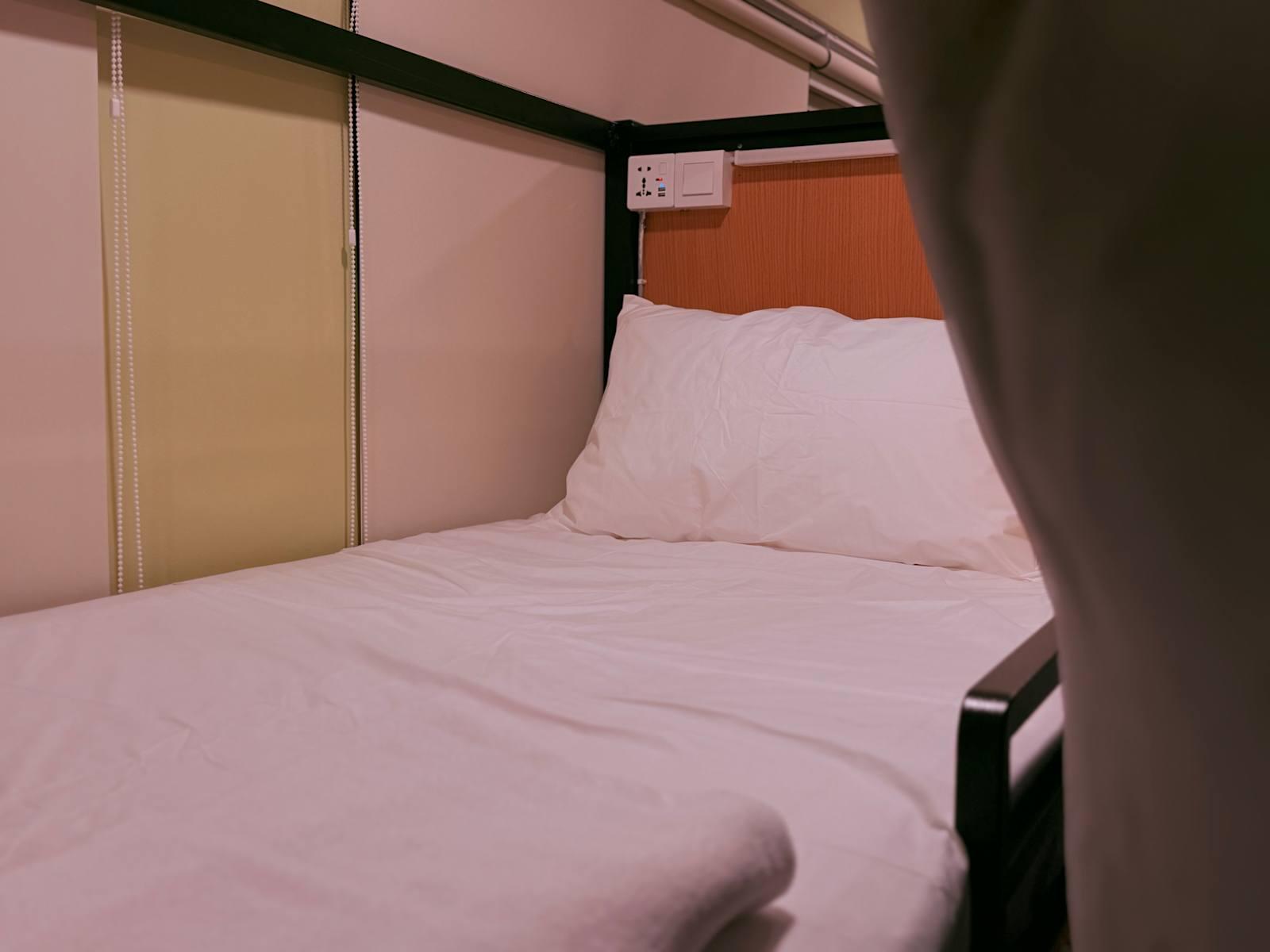 Clean hostel bed with white duvet at Poshpack Skyline Hostel